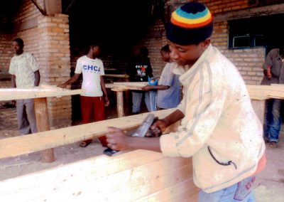 A student prepares the wood for one of the desks.
